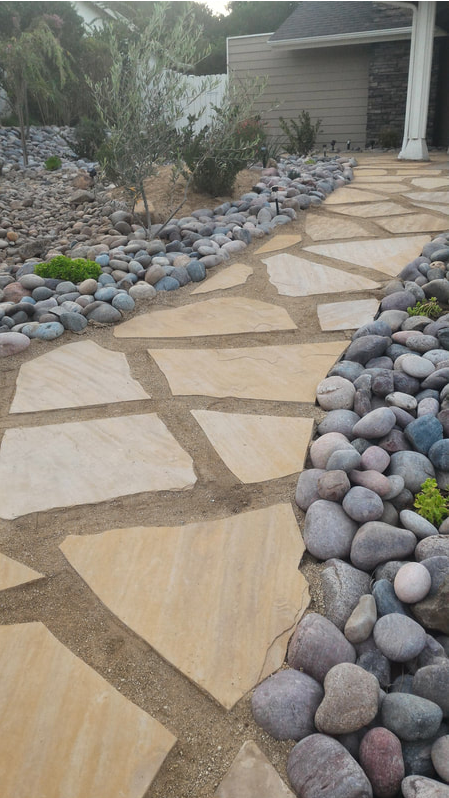 Rock slab pathway with river rocks as a border
